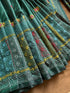 green Lambani kantha saree fabric with intricate embroidery on a brown surface